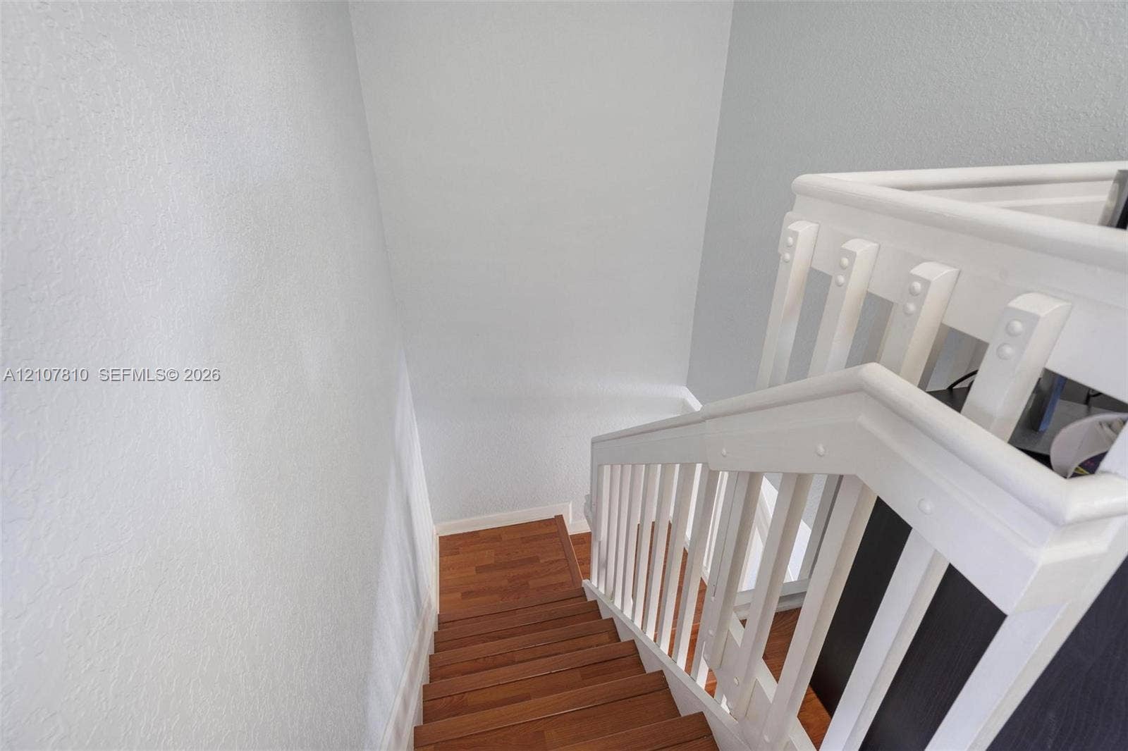 6940 NW 177th Street, #P105, Hialeah, Hialeah, FL 33015 Staircase featuring wood-finish treads and white painted balustrade with a matching handrail