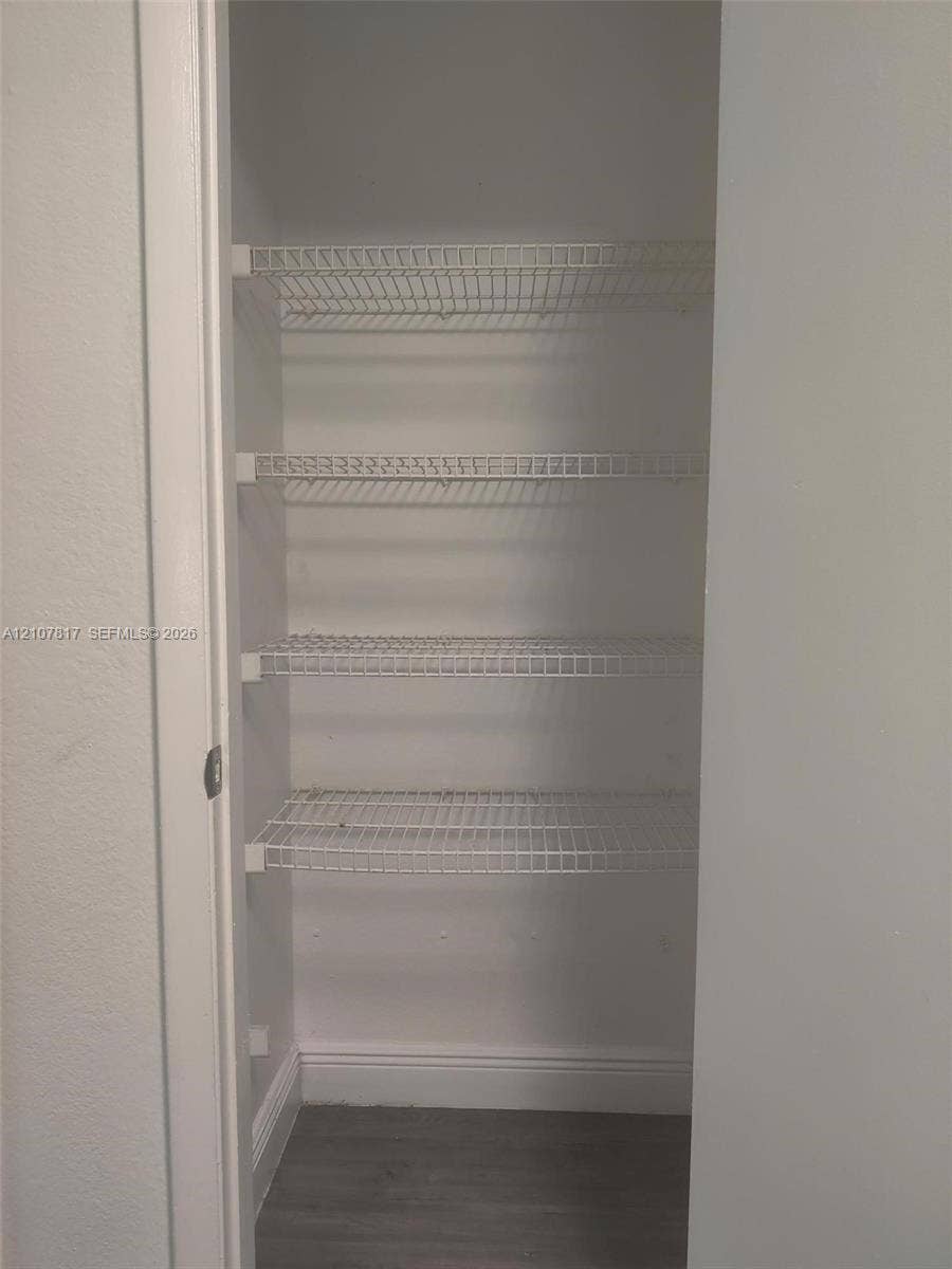1705 Palm Cove Boulevard, #1-104, Delray Beach, Delray Beach, FL 33445 Storage closet featuring four tiers of white wire shelving and wood-finish flooring