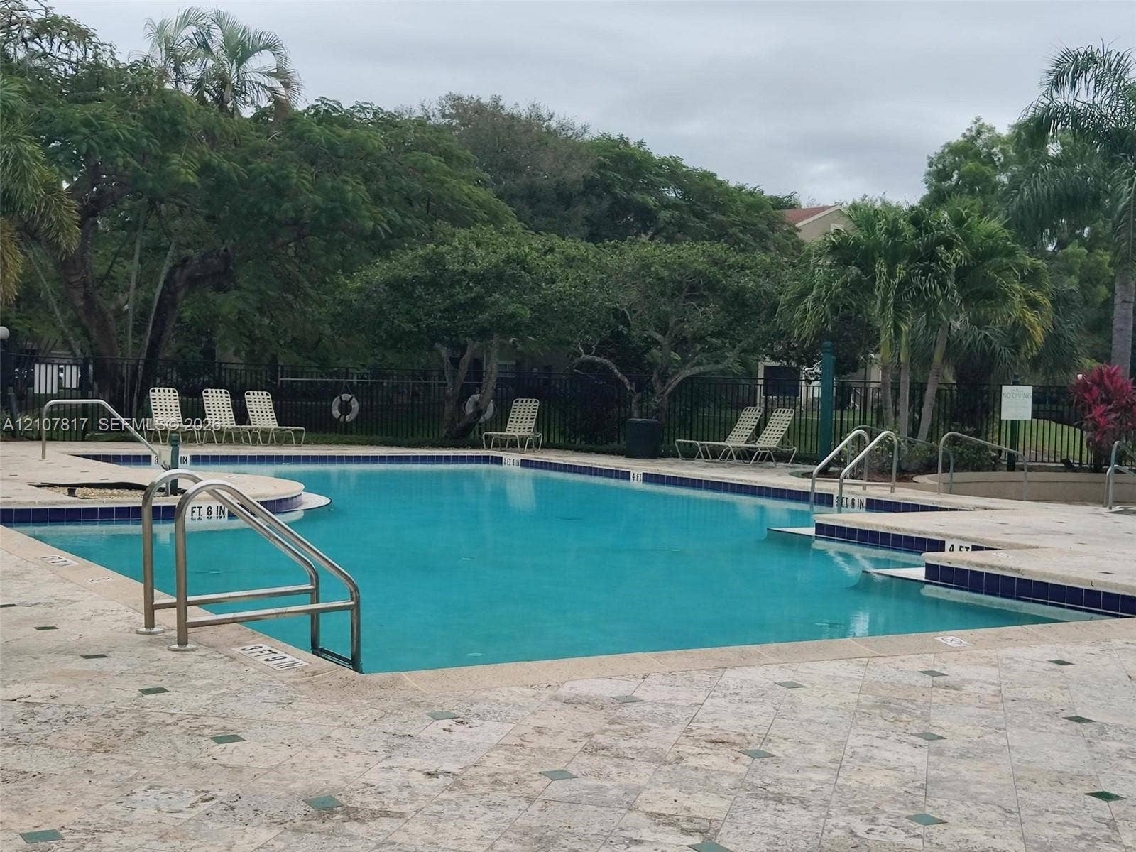 1705 Palm Cove Boulevard, #1-104, Delray Beach, Delray Beach, FL 33445 Swimming pool featuring a stone-tile deck, metal entry railings, and integrated steps