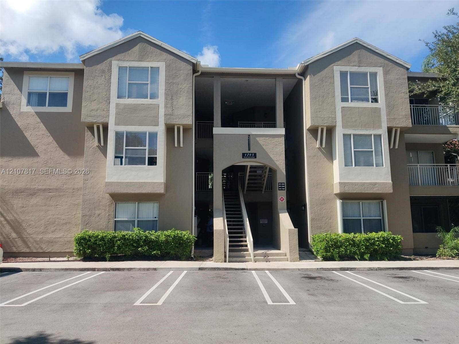1705 Palm Cove Boulevard, #1-104, Delray Beach, Delray Beach, FL 33445 Multi-story stucco exterior featuring projecting bay window profiles, recessed covered stairwell, and manicured foundation landscaping