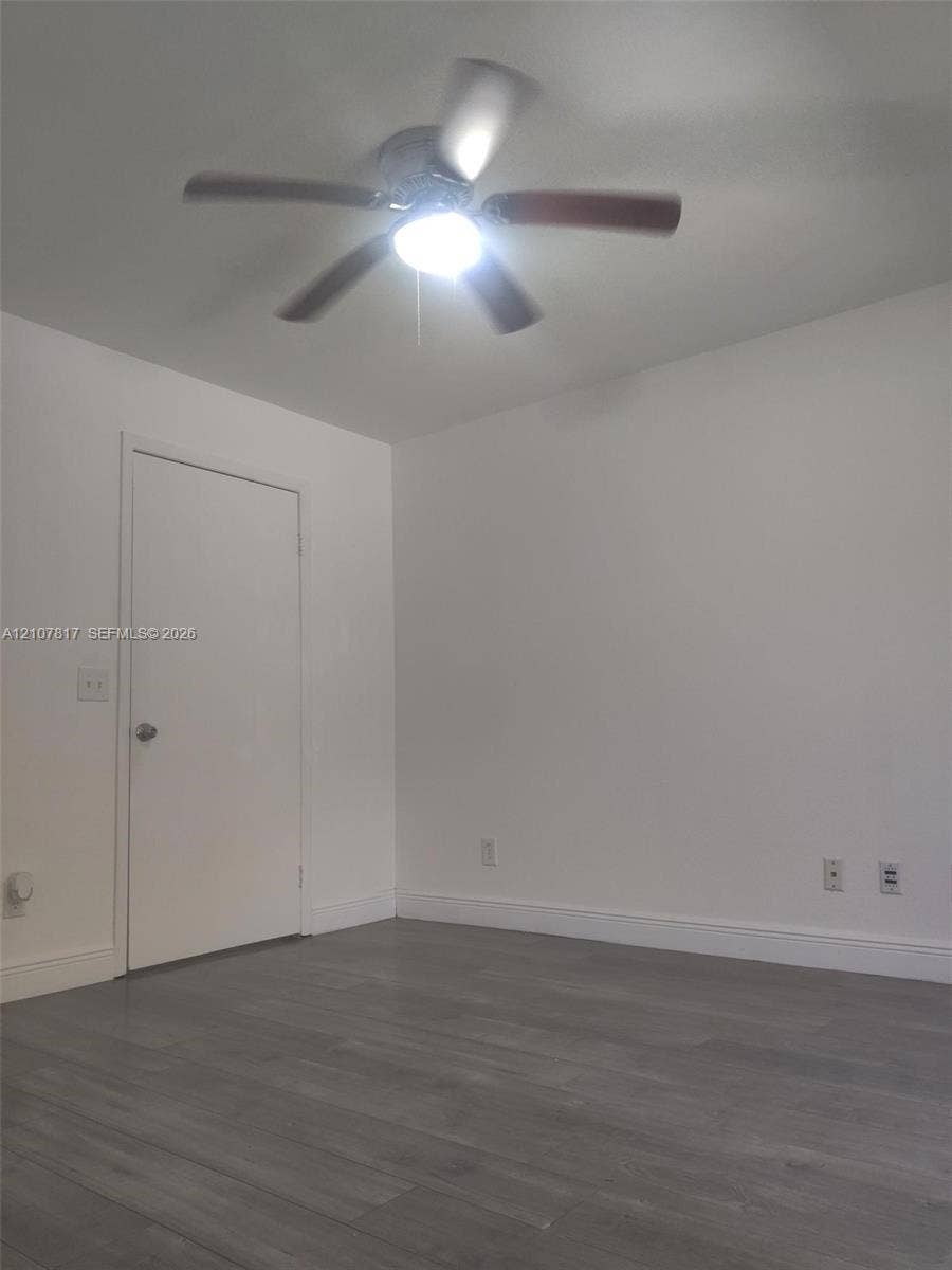 1705 Palm Cove Boulevard, #1-104, Delray Beach, Delray Beach, FL 33445 Room featuring wood-finish flooring, a neutral color palette, and a central ceiling fan with integrated lighting