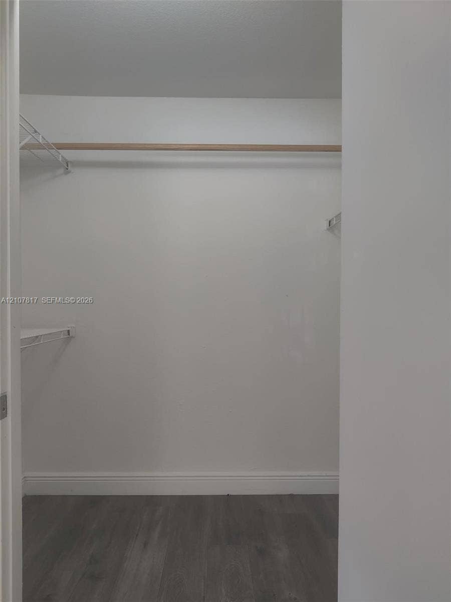 1705 Palm Cove Boulevard, #1-104, Delray Beach, Delray Beach, FL 33445 Storage space featuring wood-finish flooring, a full-width hanging rod, and wire shelving
