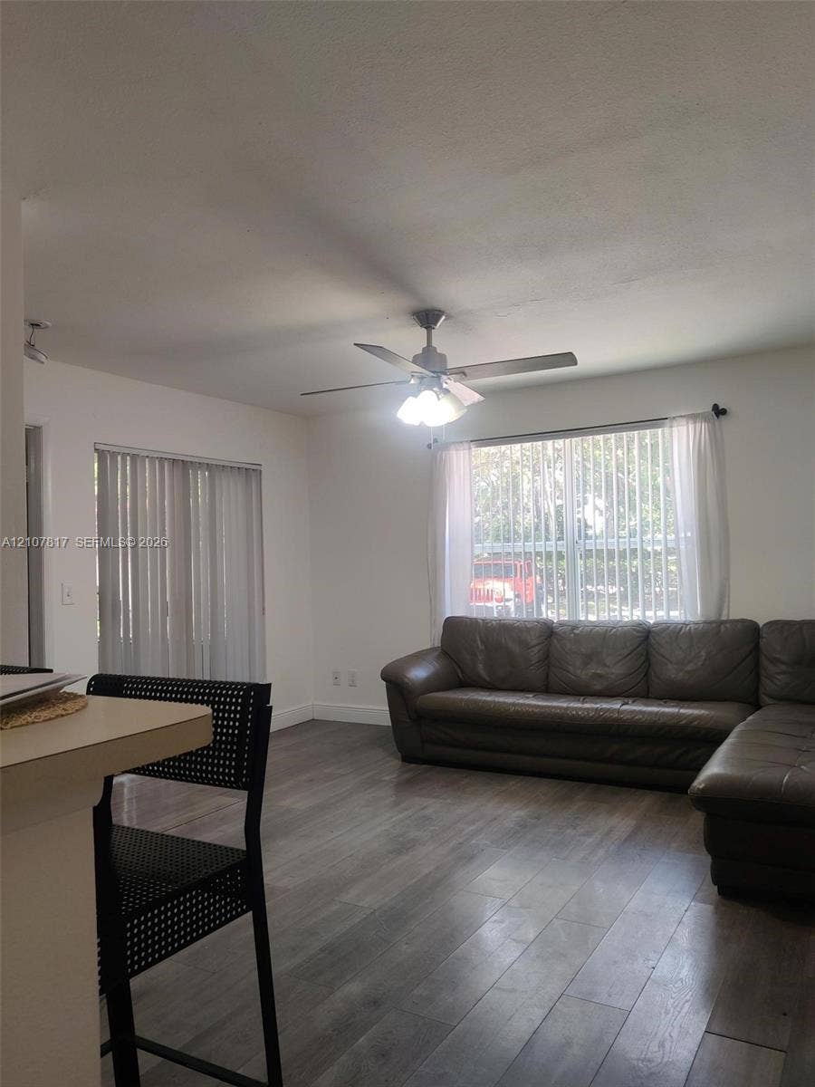 1705 Palm Cove Boulevard, #1-104, Delray Beach, Delray Beach, FL 33445 Wood-finish flooring, ceiling fan with integrated lighting, and vertical window blinds