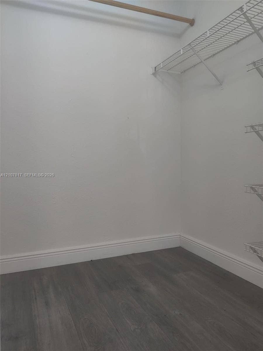 1705 Palm Cove Boulevard, #1-104, Delray Beach, Delray Beach, FL 33445 Storage area featuring wood-finish flooring and white shelving with an integrated hanging rod