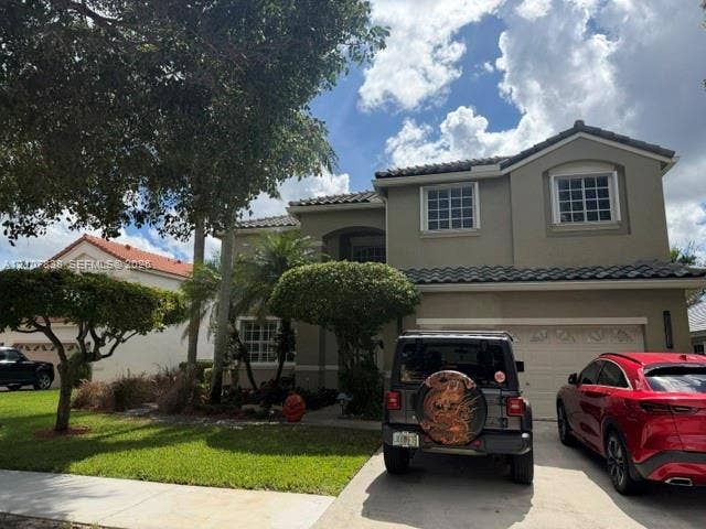 133 Cameron Drive, Weston, FL 33326 Two-story exterior featuring a stucco facade, multi-gabled roofline with tile roofing, grid-pattern windows, and an attached two-car garage