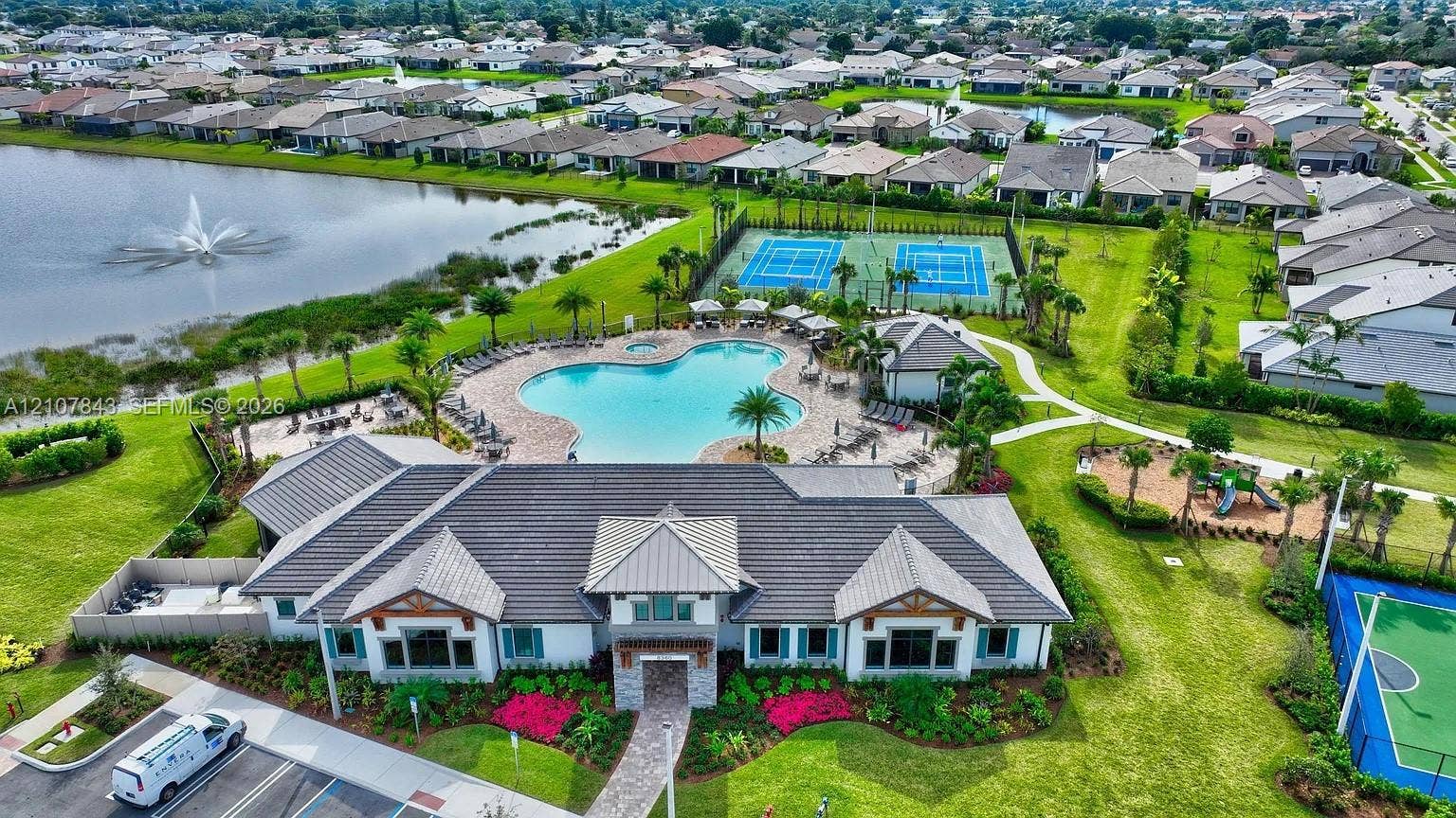 4949 Blistering Way, Lake Worth, FL 33467 Community clubhouse featuring a swimming pool, two tennis courts, and a multi-purpose hard surface court, all situated on a lakefront lot