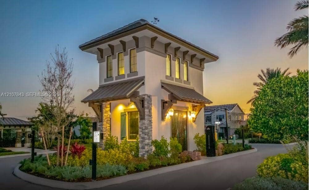 4949 Blistering Way, Lake Worth, FL 33467 Stucco exterior guardhouse featuring decorative corbel brackets, stone veneer masonry, metal-panel roofing, and custom metal light fixtures