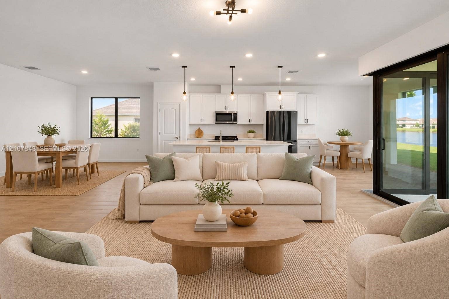 4949 Blistering Way, Lake Worth, FL 33467 Open-concept interior featuring wood-finish flooring, recessed lighting, white cabinetry, a center island, and large multi-panel sliding glass doors