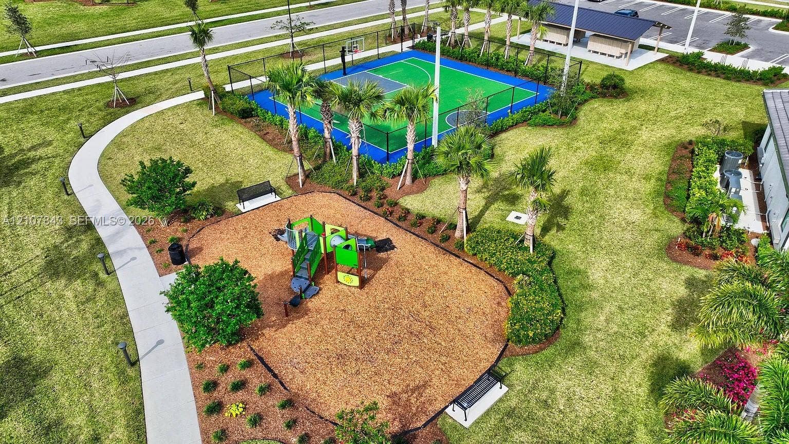 4949 Blistering Way, Lake Worth, FL 33467 Fenced basketball court, multi-component playground with mulch surfacing, paved walking paths, covered outdoor pavilion, and mature landscaping