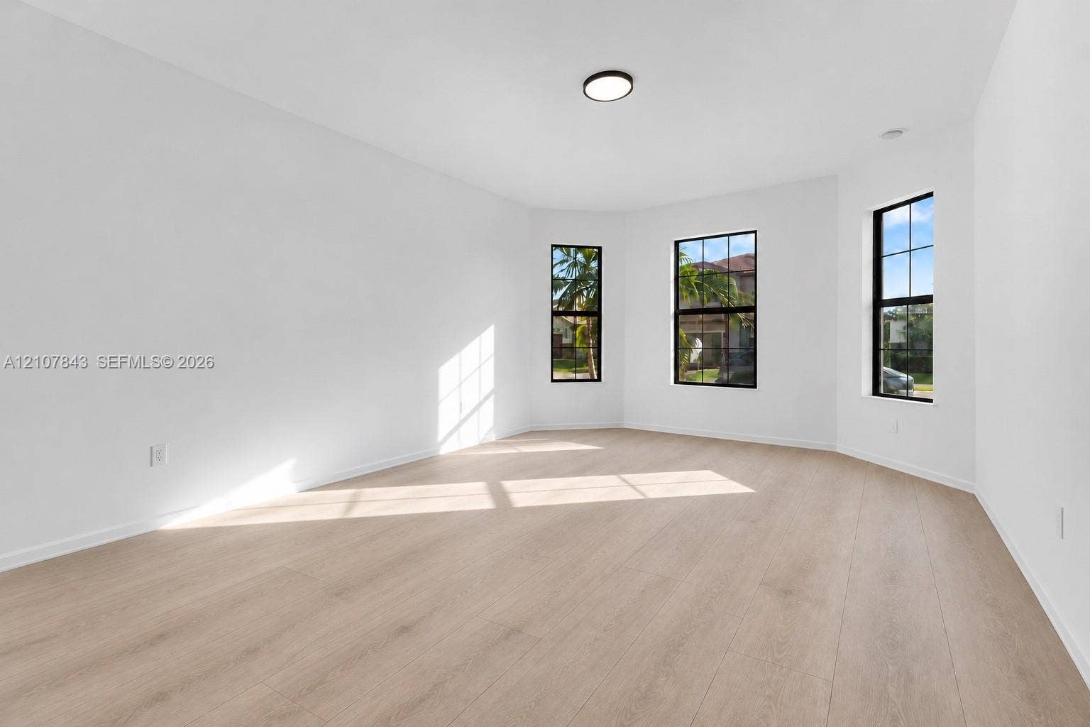 4949 Blistering Way, Lake Worth, FL 33467 Neutral interior space featuring wood-finish flooring, a bay window configuration, and black-framed windows