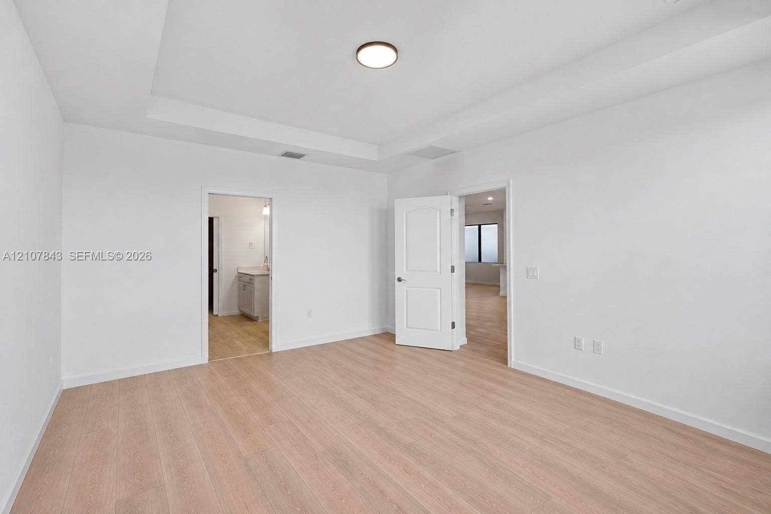 4949 Blistering Way, Lake Worth, FL 33467 Interior space featuring wood-finish flooring, tray ceiling, recessed lighting, and white paneled doors