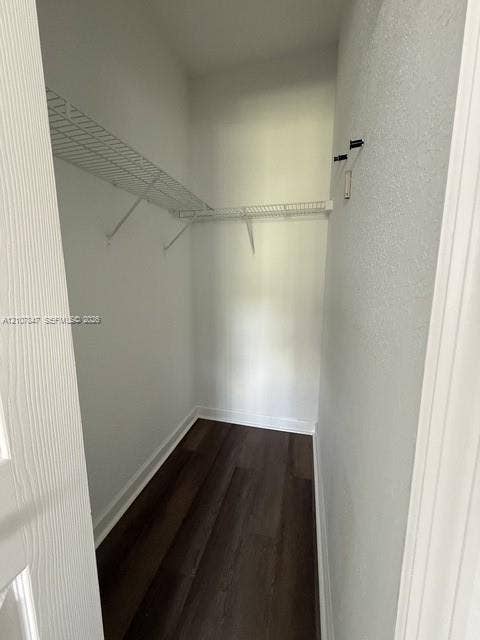 Storage space featuring white wire shelving and wood-finish flooring