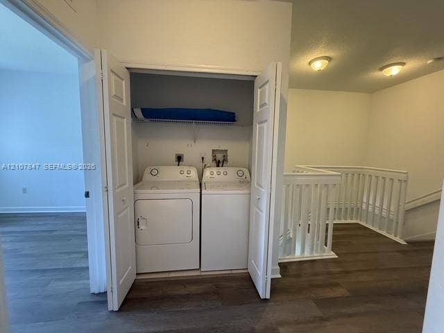 Laundry closet featuring bi-fold doors, white top-load washer and dryer, wire shelving, wood-finish flooring, and white spindle railing