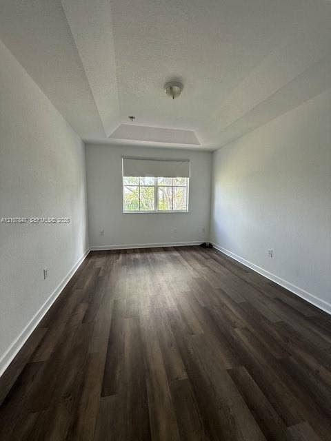 Tray ceiling, wood-finish flooring, and single-pane window with roller shade