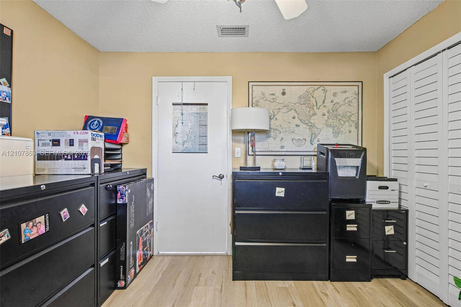 Room featuring wood-finish flooring, a ceiling fan, and louvered bi-fold closet doors