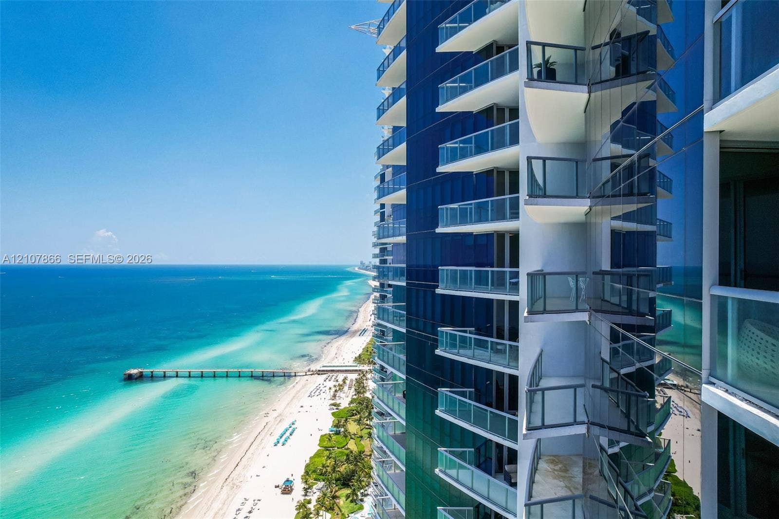 17121 Collins Avenue, #2608, Sunny Isles Beach, FL 33160 High-rise exterior featuring glass curtain walls and private cantilevered balconies with glass railings overlooking the coastline