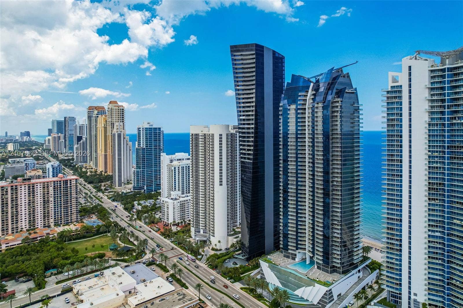 17121 Collins Avenue, #2608, Sunny Isles Beach, FL 33160 High-rise residential tower featuring glass-curtain exterior walls, tiered balconies, integrated pool deck, and coastal positioning