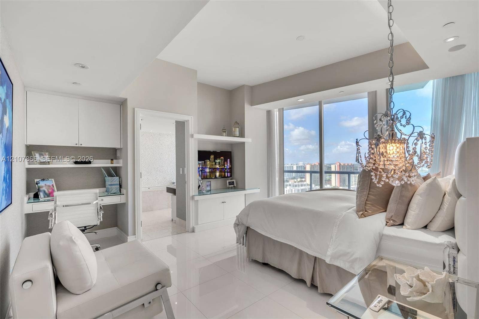 17121 Collins Avenue, #2608, Sunny Isles Beach, FL 33160 Floor-to-ceiling windows, built-in desk with overhead cabinetry, polished tile flooring, recessed lighting, and ornate crystal chandelier