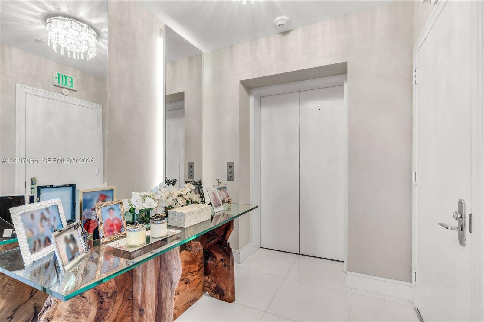 17121 Collins Avenue, #2608, Sunny Isles Beach, FL 33160 Elevator entry featuring white tile flooring, neutral wall finish, and a ceiling-mounted crystal chandelier
