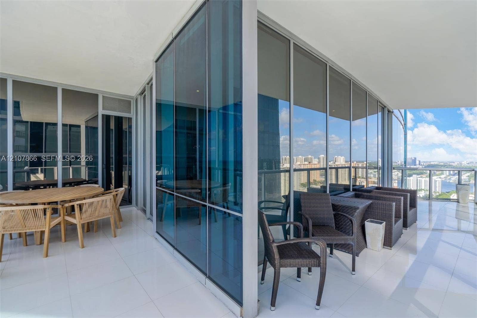 17121 Collins Avenue, #2608, Sunny Isles Beach, FL 33160 Wraparound balcony featuring floor-to-ceiling glass paneling, reflective window glazing, and large-format tile flooring