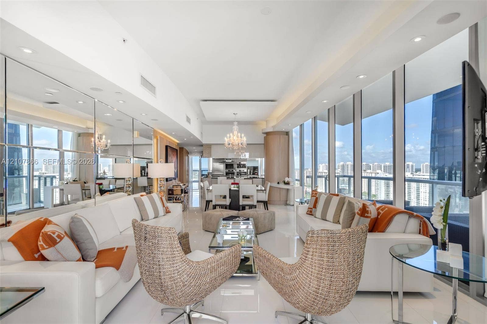 17121 Collins Avenue, #2608, Sunny Isles Beach, FL 33160 Floor-to-ceiling windows, full-wall mirror installation, polished tile flooring, recessed ceiling lighting, and built-in crystal chandelier