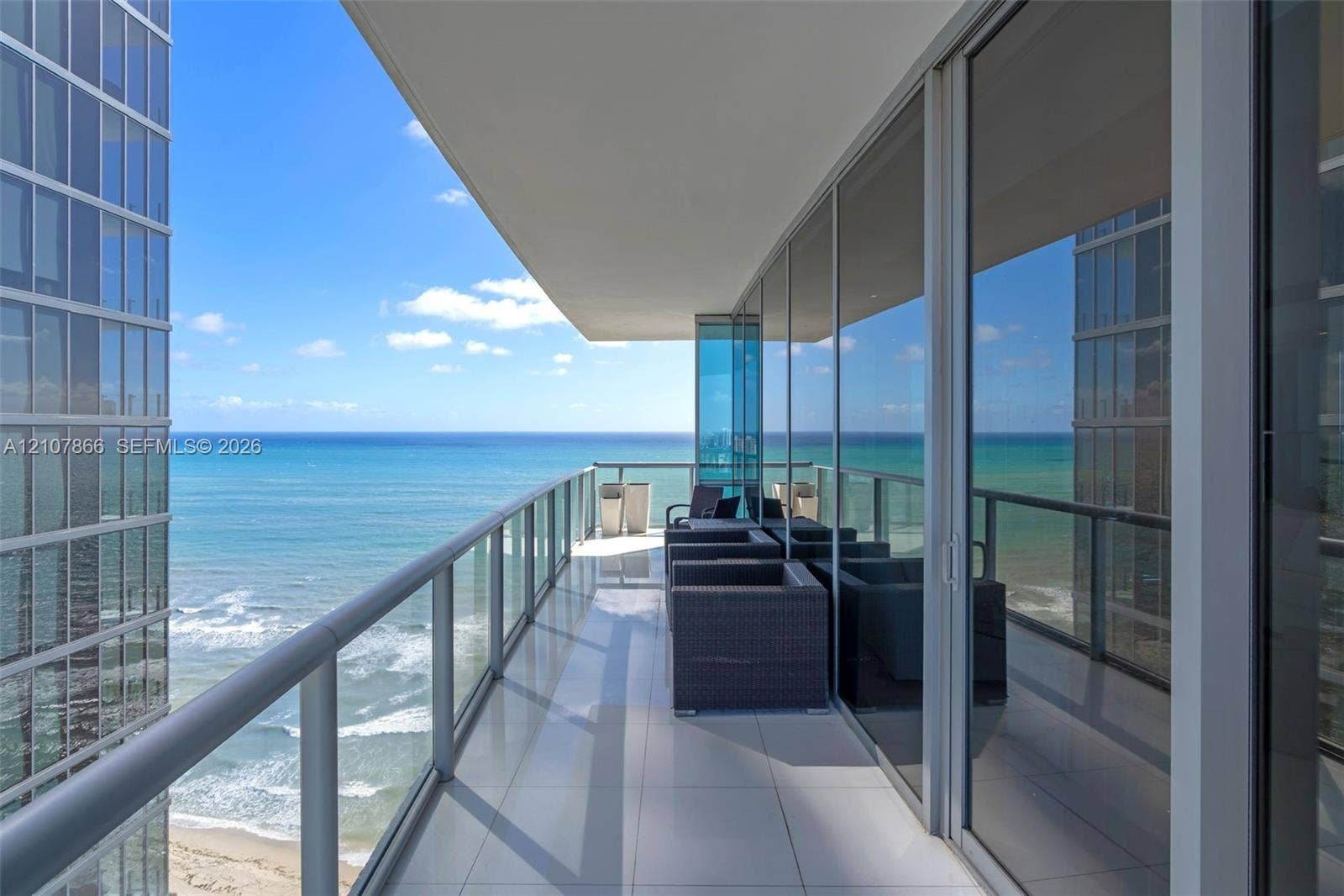17121 Collins Avenue, #2608, Sunny Isles Beach, FL 33160 Covered balcony featuring floor-to-ceiling glass paneling, metal railing, and light-toned tile flooring