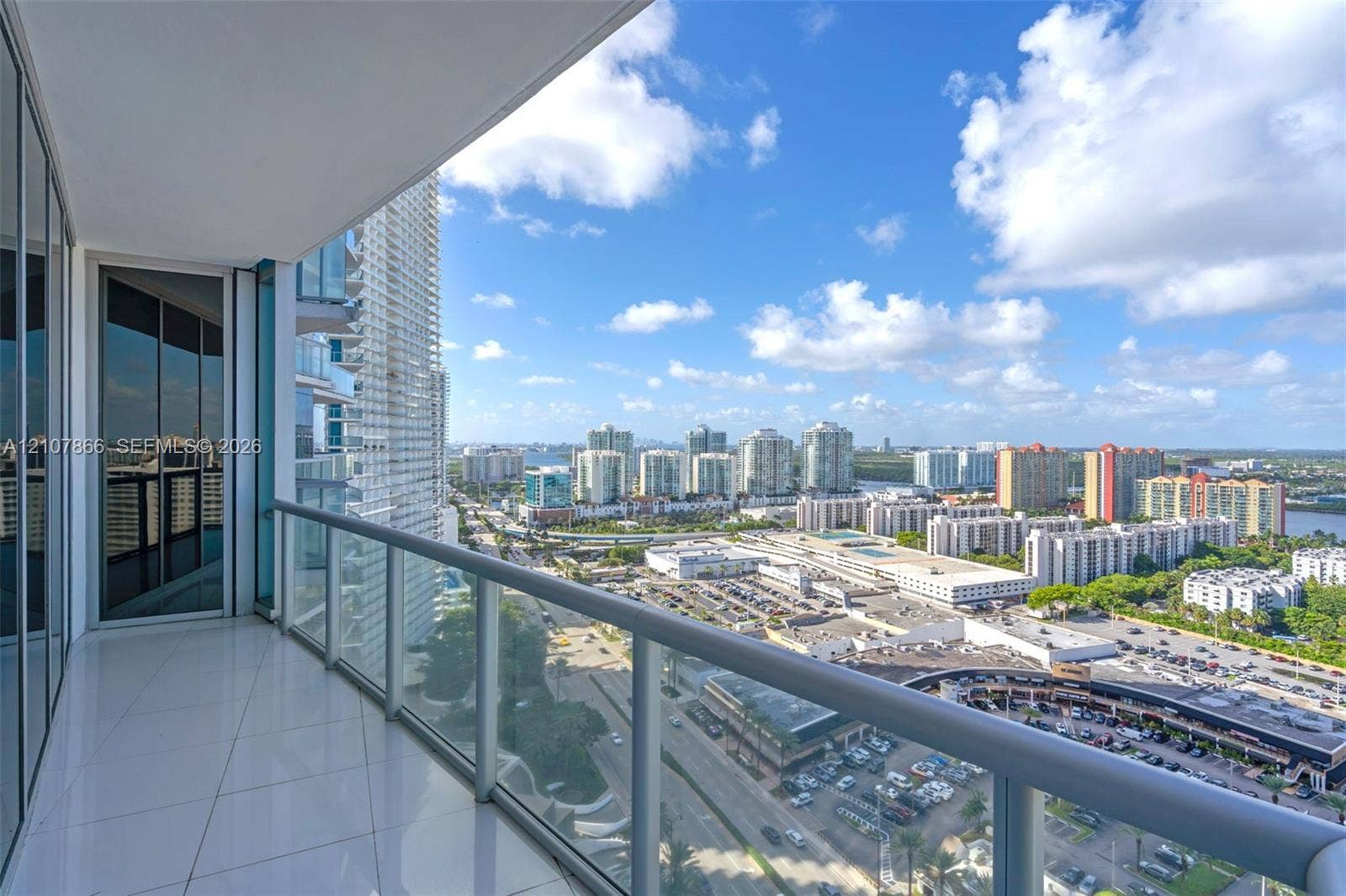 17121 Collins Avenue, #2608, Sunny Isles Beach, FL 33160 Covered balcony featuring white tile flooring, floor-to-ceiling glass paneling, and a metal railing