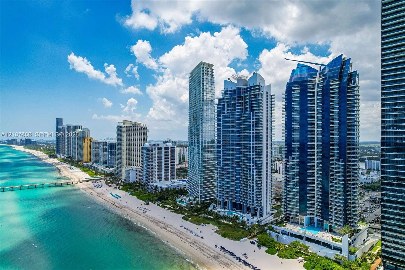 17121 Collins Avenue, #2608, Sunny Isles Beach, FL 33160 Coastal high-rise buildings featuring floor-to-ceiling glass facades, prominent balconies, and direct oceanfront positioning