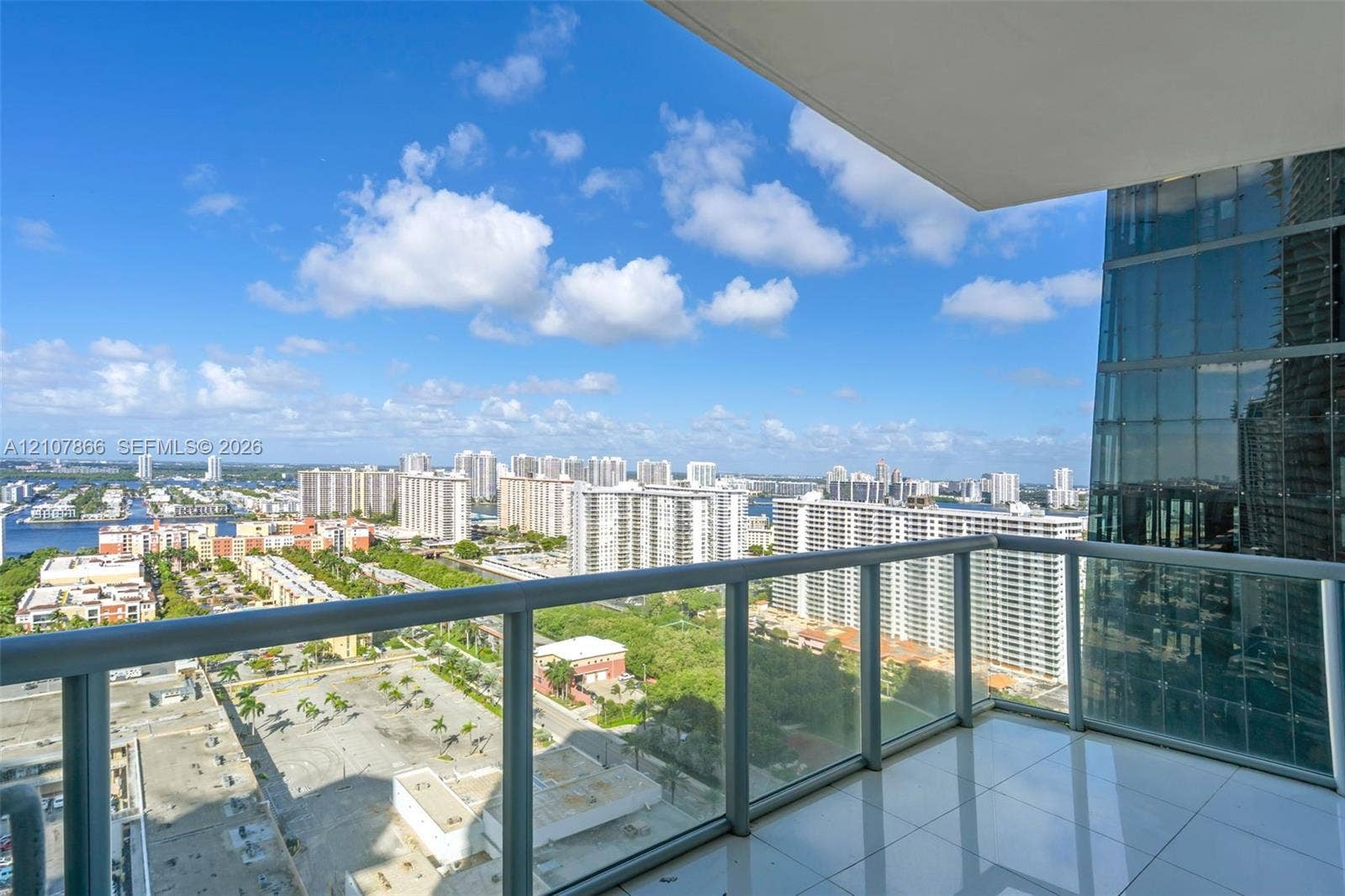 17121 Collins Avenue, #2608, Sunny Isles Beach, FL 33160 Private balcony featuring glass panel railings, tiled flooring, and high-rise urban surroundings