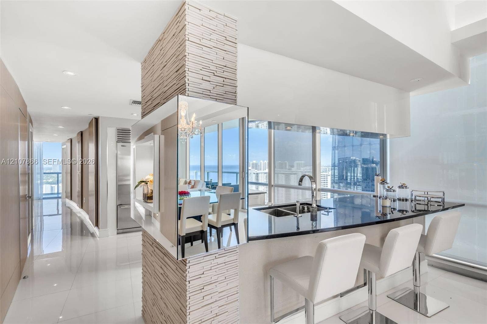 17121 Collins Avenue, #2608, Sunny Isles Beach, FL 33160 Stone-clad structural pillar, polished dark countertop, stainless steel dual-basin undermount sink, floor-to-ceiling glass windows, and glossy tile flooring