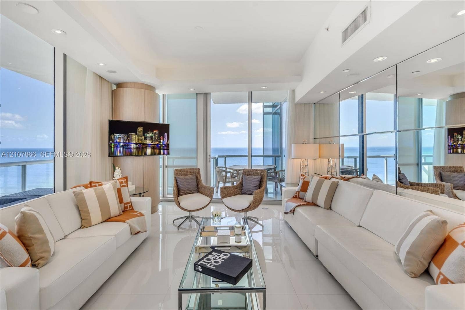 17121 Collins Avenue, #2608, Sunny Isles Beach, FL 33160 Floor-to-ceiling glass walls, polished stone flooring, recessed lighting, mirrored wall accents, and a private balcony