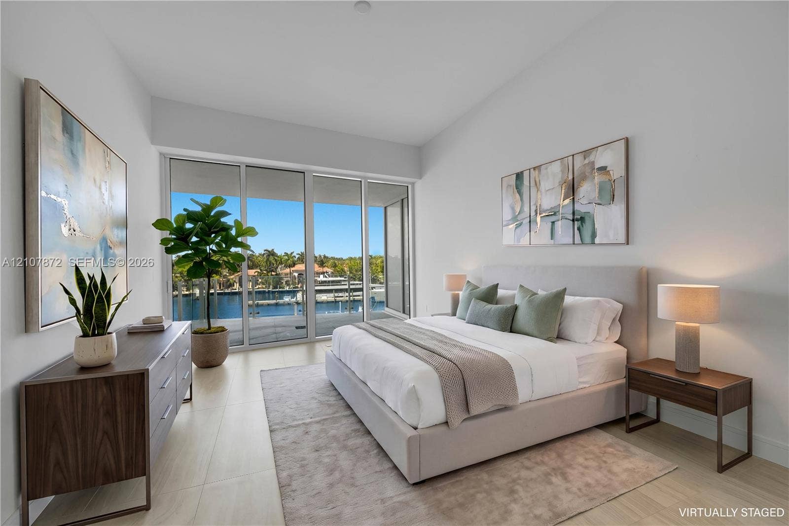 2221 SE 17th Street, #301, Fort Lauderdale, FL 33316 Floor-to-ceiling sliding glass doors, neutral tile flooring, and direct access to an outdoor balcony featuring a waterfront and marina setting