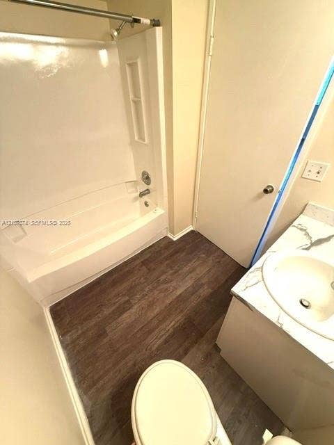8402 Coral Lake Way, #8402, Coral Springs, Coral Springs, FL 33065 Bathroom featuring wood-finish flooring, a white bathtub and shower surround, and a vanity topped with a stone-finish counter and integrated sink