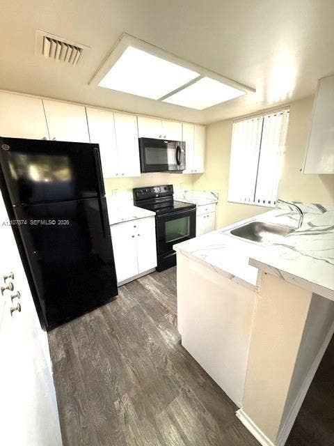 8402 Coral Lake Way, #8402, Coral Springs, Coral Springs, FL 33065 Kitchen featuring white cabinetry, stone-finish countertops, black appliances, a stainless steel sink, and wood-finish flooring