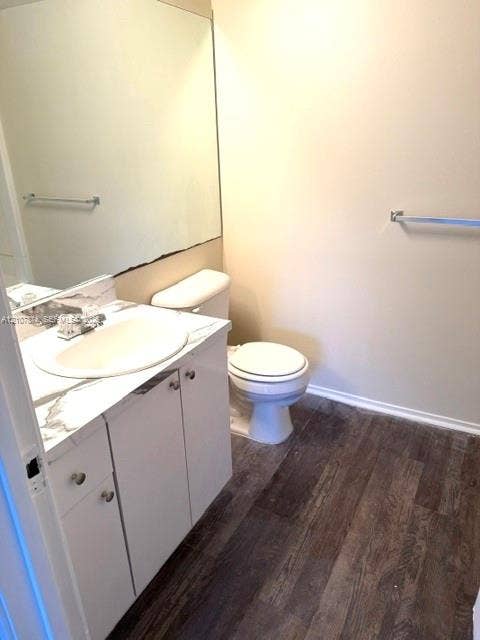 8402 Coral Lake Way, #8402, Coral Springs, Coral Springs, FL 33065 Vanity featuring a white countertop with grey veining, integrated oval sink, wood-finish flooring, full-width mirror, and chrome fixtures