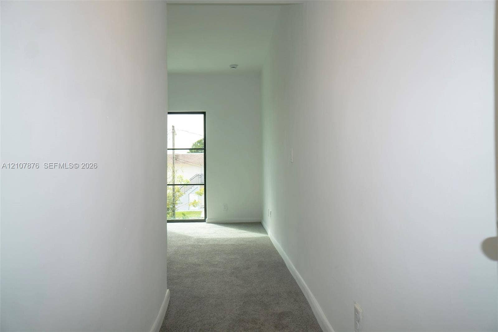 2526 Pierce Street, #8, Hollywood, Hollywood, FL 33020 Hallway featuring neutral wall paint, carpeted flooring, and a large window with black mullions