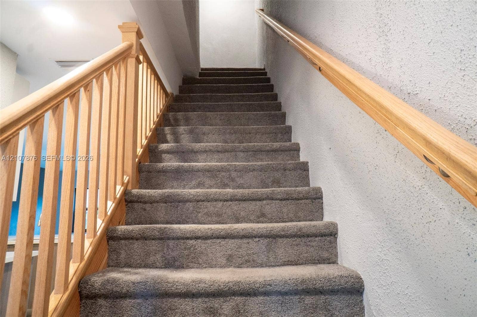 2526 Pierce Street, #8, Hollywood, Hollywood, FL 33020 Staircase featuring wall-to-wall carpeting, light-tone wood balusters, a matching wood handrail, and textured wall finishes