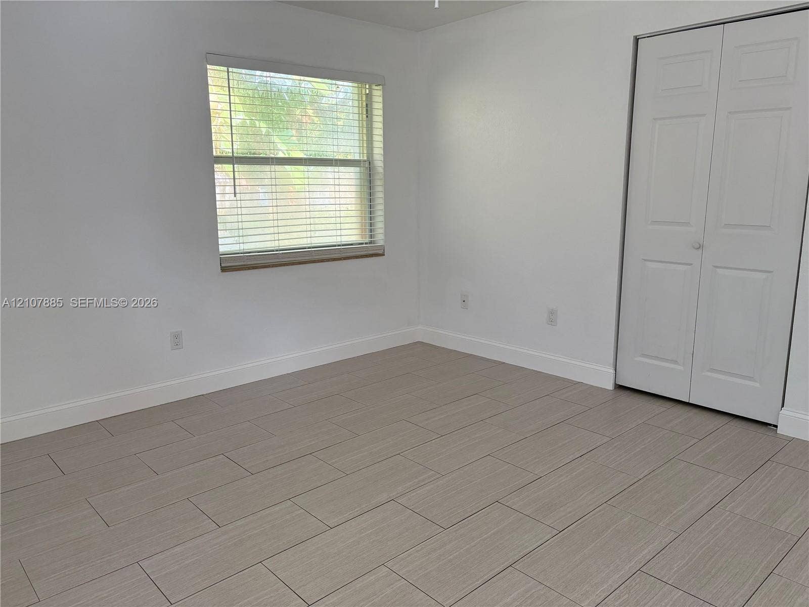 4840 NW 10th Terrace, Fort Lauderdale, Fort Lauderdale, FL 33309 Neutral-toned tile flooring, light-filled interior, and dual-panel closet doors