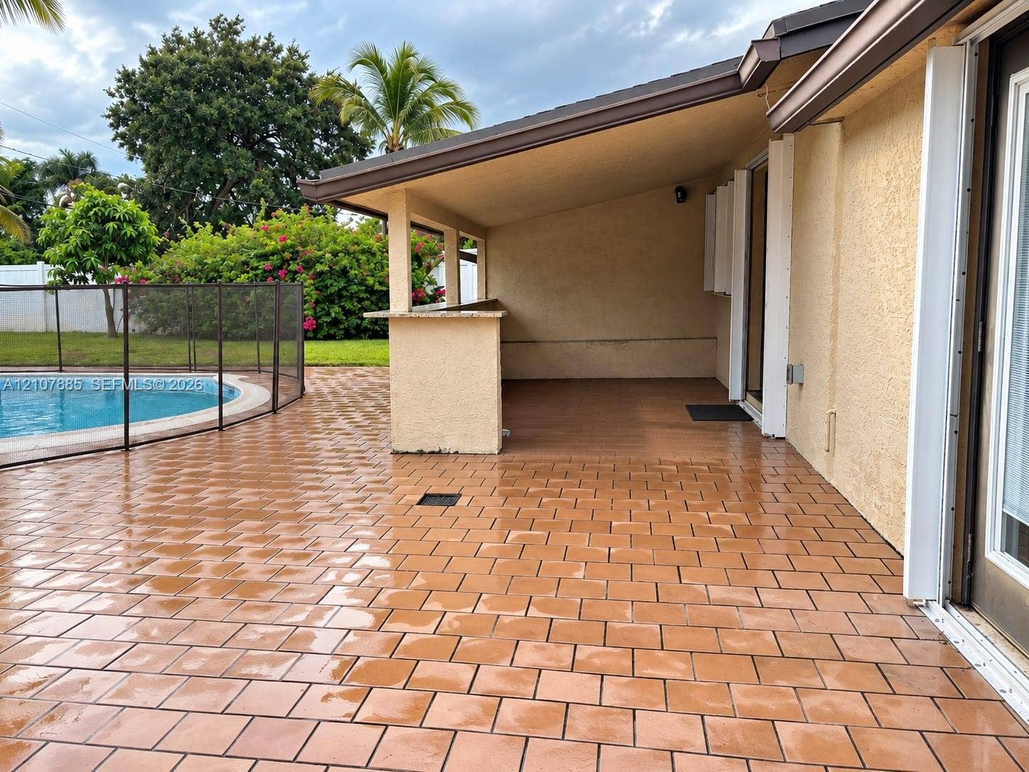 4840 NW 10th Terrace, Fort Lauderdale, Fort Lauderdale, FL 33309 Covered patio featuring a built-in bar, tiled flooring, and a swimming pool with a protective mesh enclosure