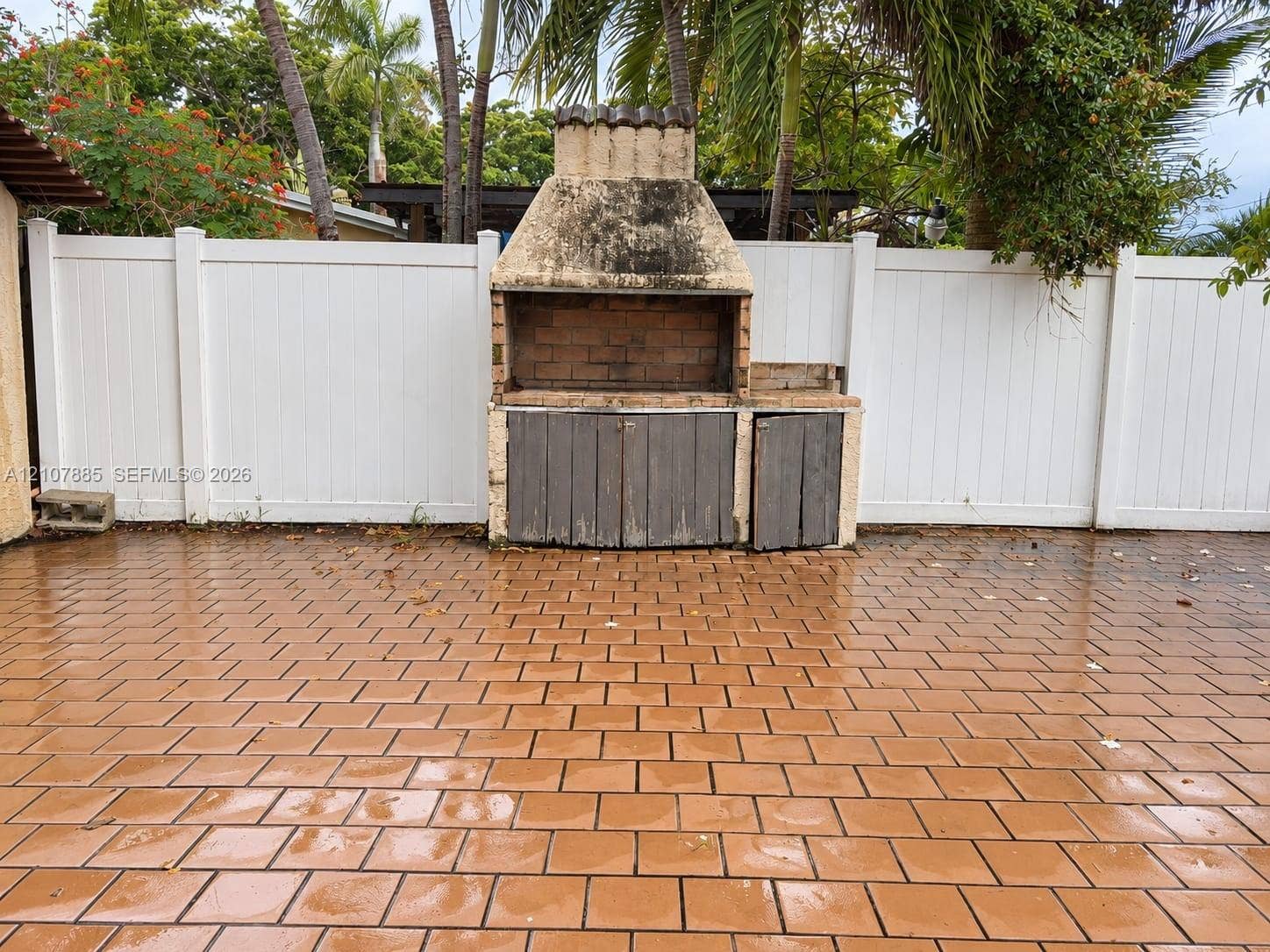4840 NW 10th Terrace, Fort Lauderdale, Fort Lauderdale, FL 33309 Outdoor patio featuring a paved tile floor, built-in masonry grill, and white vinyl privacy fencing