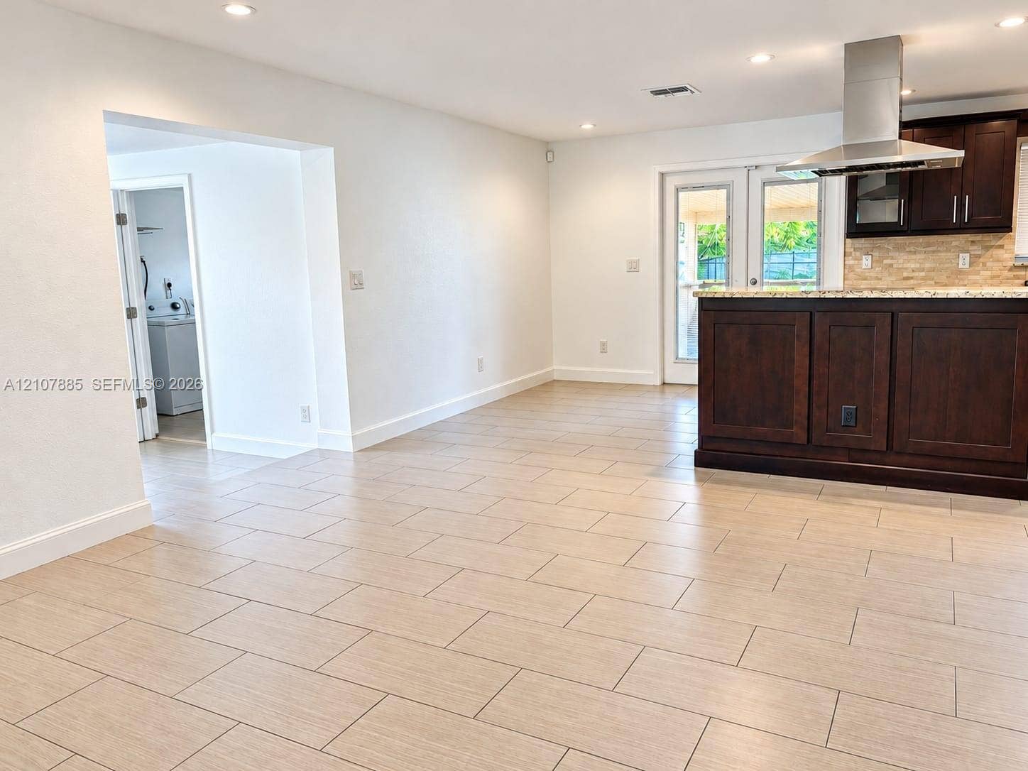4840 NW 10th Terrace, Fort Lauderdale, Fort Lauderdale, FL 33309 Kitchen featuring dark wood cabinetry, stone-finish countertops, stainless steel chimney-style range hood, and tile flooring
