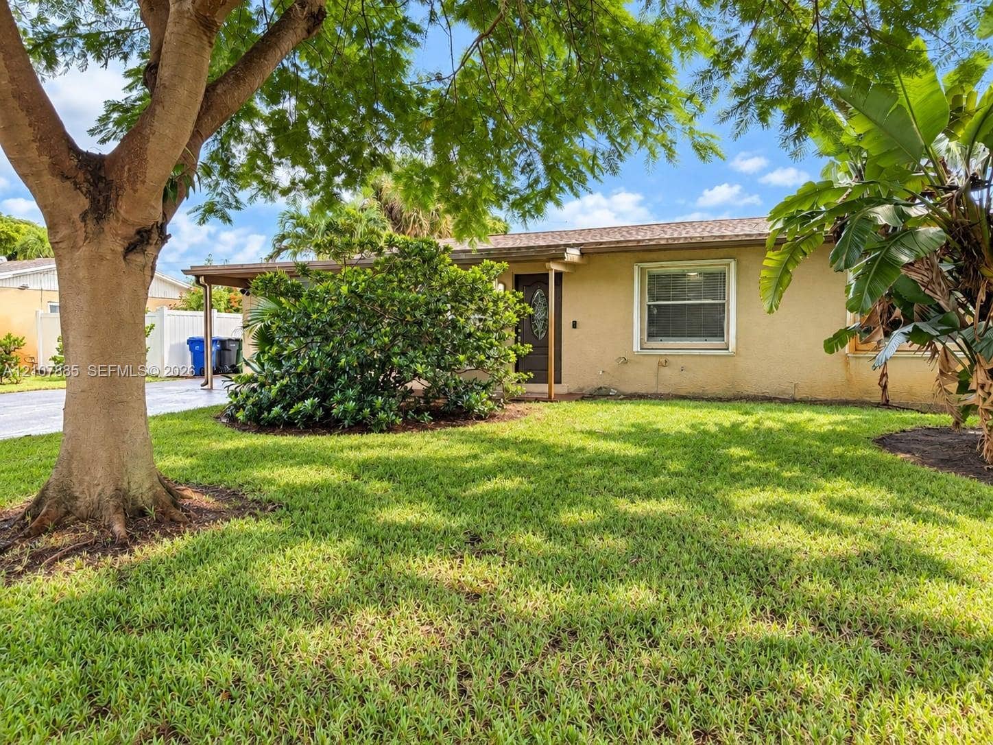 4840 NW 10th Terrace, Fort Lauderdale, Fort Lauderdale, FL 33309 Single-story exterior featuring a stucco facade, covered entryway, and mature landscaping