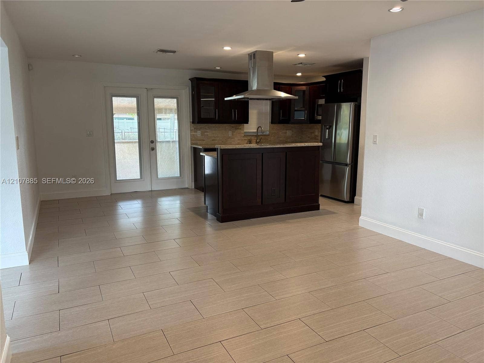 4840 NW 10th Terrace, Fort Lauderdale, Fort Lauderdale, FL 33309 Kitchen featuring dark wood-finish cabinetry, stone countertops, stainless steel appliances, a stainless steel range hood, and tile flooring