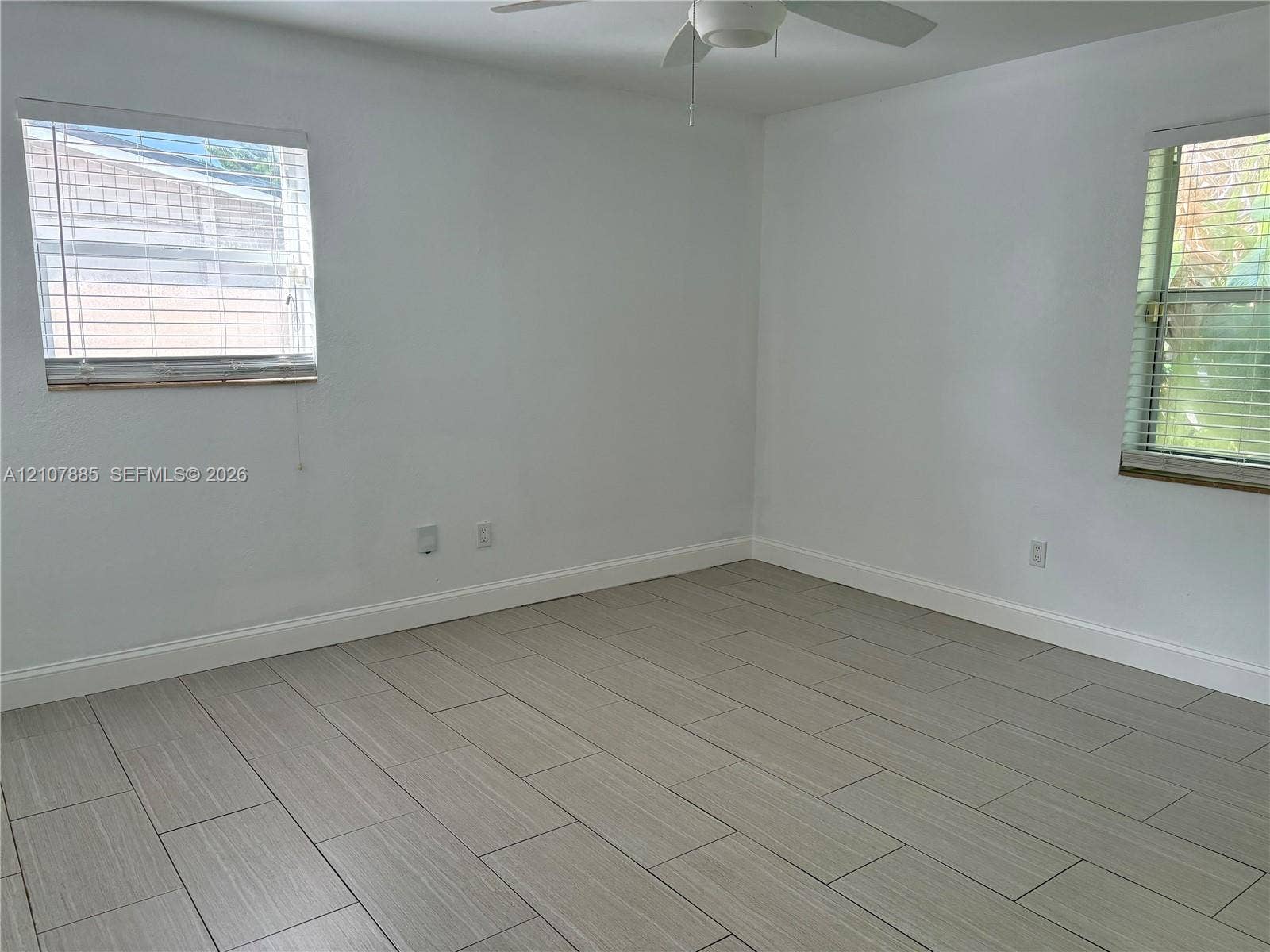 4840 NW 10th Terrace, Fort Lauderdale, Fort Lauderdale, FL 33309 Interior room featuring neutral wall finishes, tile flooring, dual windows with horizontal blinds, and a ceiling fan