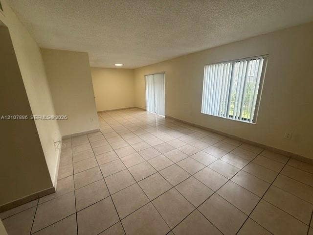 8411 Coral Lake Manor, #8441, Coral Springs, Coral Springs, FL 33065 Large living area featuring neutral tile flooring, sliding glass door, oversized window with vertical blinds, and recessed ceiling lighting
