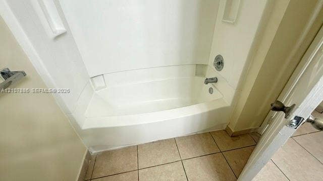 8411 Coral Lake Manor, #8441, Coral Springs, Coral Springs, FL 33065 Bathtub and shower combination featuring a white molded surround with integrated storage niches, chrome-finish faucet hardware, and ceramic tile flooring