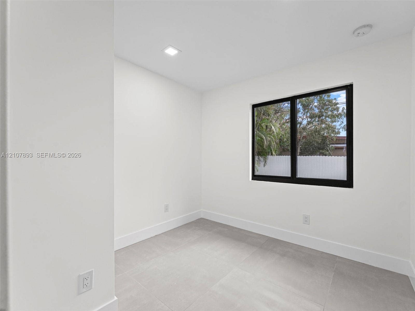 610 NE 164th Terrace, Miami, FL 33162 Neutral-toned tile flooring, recessed ceiling lighting, and a window with a black frame