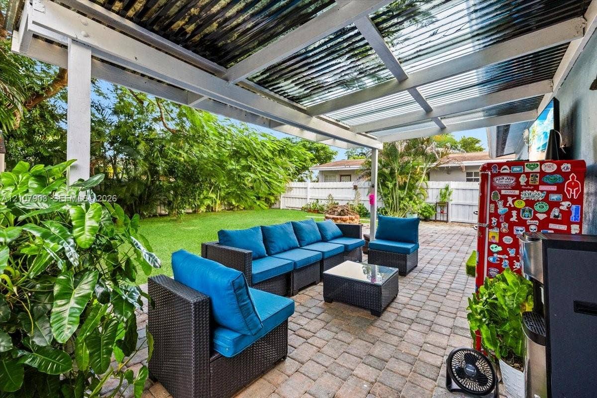 924 SW 15th Terrace, Fort Lauderdale, FL 33312 Covered patio featuring a corrugated translucent roof, paver flooring, and white privacy fencing