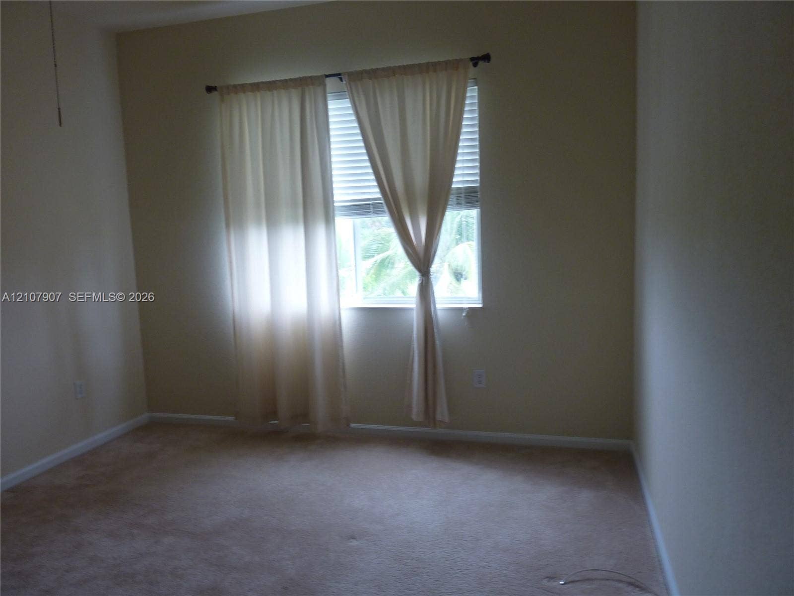 Room featuring neutral wall tones, carpeted flooring, and a window with integrated blinds