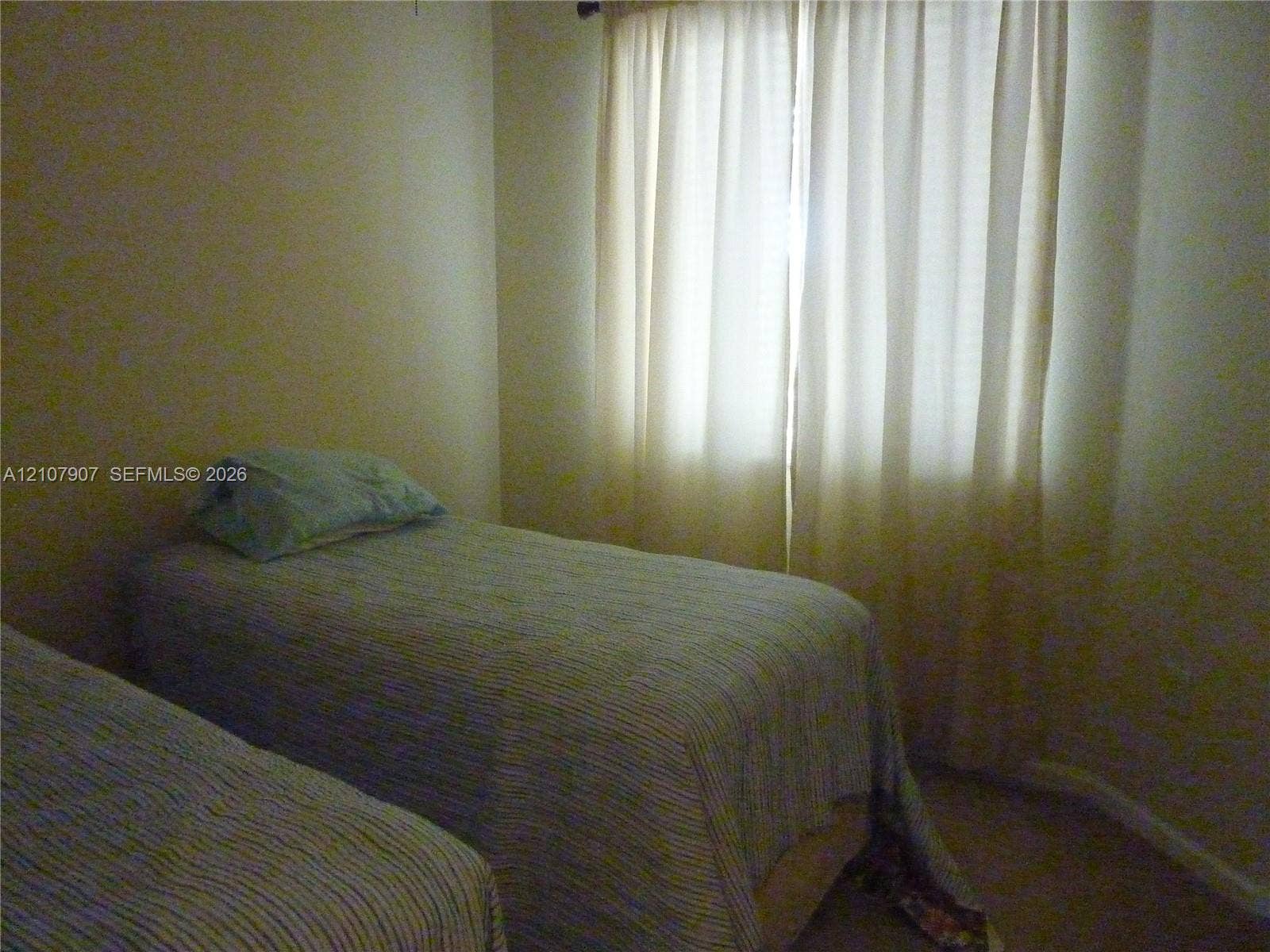 Neutral-toned interior room featuring wall-to-wall carpeting and a large window